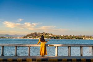 a woman in a yellow dress standing on a pier near the water at Panna Vilas - A Lake Facing Boutique Hotel in Udaipur