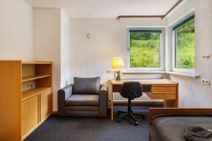 a bedroom with a desk and a chair and a bed at Ferienhaus Adelheid in Bad Grund