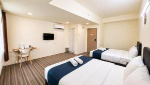 a hotel room with two beds and a television at Hotel Seri Warisan Melaka in Malacca +25 photos