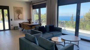 a living room with a couch and a table with chairs at Carmelia Villas in Agios Nikitas