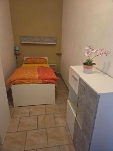 a small bedroom with a bed with orange sheets at Ferienwohnung Tirolerhof in Horn