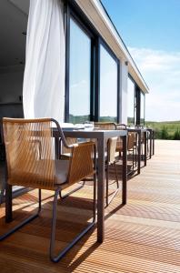 a row of tables and chairs on a balcony at Fletcher Hotel - Restaurant Elzenduin in Ter Heijde