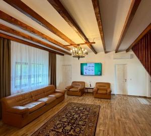 a living room with a couch and two chairs at Casa cu Dor in Odăile