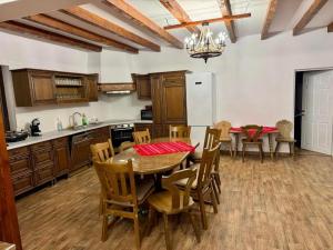 a kitchen with a table and chairs and a refrigerator at Casa cu Dor in Odăile