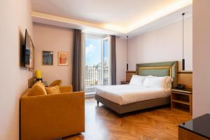 ein Schlafzimmer mit einem Bett, einem Stuhl und einem Fenster in der Unterkunft Hotel Giolli Nazionale in Rom + 139 Fotos