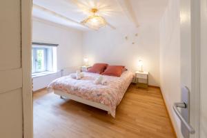 a bedroom with a bed and two lights on the ceiling at Gîte L'instant Vosges in Aydoilles
