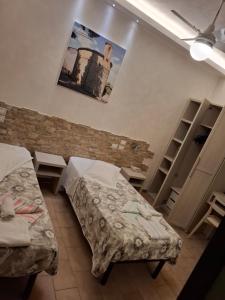 a room with two beds and a brick wall at Hotel Pierina in Castrocaro Terme
