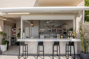 a bar with stools in front of a building at Mancave Sanctum Caldera Suites in Oia