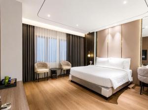 a bedroom with a bed and a desk and chairs at Sunshine Grand Hotel in Móng Cái