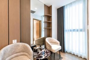 a living room with two chairs and a table at Sunshine Grand Hotel in Móng Cái
