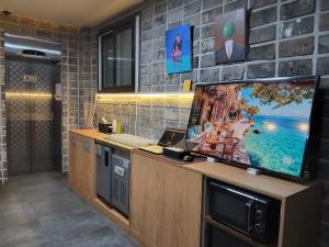 a kitchen with a large flat screen tv on a counter at Icheon Paradise Hotel in Saebaem-gol