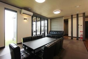 a conference room with a table and leather chairs at ピッコラ カーサ コリーナ 愛犬と泊まれる貸別荘 in Awaji