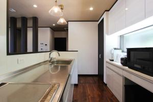 a kitchen with a sink and a microwave at ピッコラ カーサ コリーナ 愛犬と泊まれる貸別荘 in Awaji