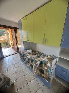 a bedroom with a bed and green cabinets at Residence Orizzonti app n 21 in Golfo Aranci