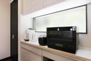 a microwave sitting on top of a counter at ピッコラ カーサ コリーナ 愛犬と泊まれる貸別荘 in Awaji