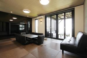 a living room with a table and leather chairs at ピッコラ カーサ コリーナ 愛犬と泊まれる貸別荘 in Awaji