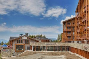 a building under construction next to two tall buildings at Résidence Odalys L'Ecrin Blanc in La Rosière