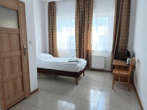 a small bedroom with a bed and a window at Hostel Wólka Kosowska z prywatnymi łazienkami in Wólka Kosowska