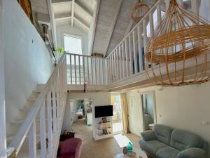 a living room with a staircase with a couch and a tv at Cosy 21 in Ialysos