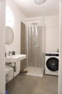 a shower in a bathroom with a sink and a washing machine at Moderne Sauerhof Apartments in Baden +123 photos