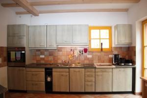 a kitchen with white cabinets and a sink and a window at Haus Maja in Kurort Rathen