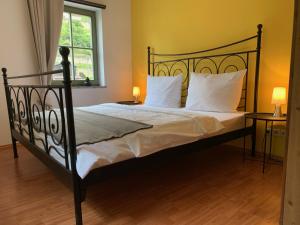 a bedroom with a large bed with white pillows at Haus Maja in Kurort Rathen +8 photos