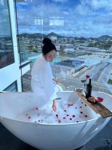 a woman in a bath tub with red hearts in it at Lyn's Hotel Da Lat in Da Lat