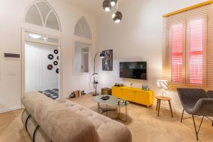 a living room with a couch and a tv at DAR MEMOIR Apart Hotel in Al Mudawwar