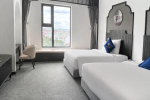a hotel room with two beds and a window at Sandals Everyday Hotel in Tuy Hoa +42 photos