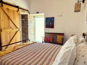 a bedroom with a large bed with a wooden door at Casa da Curva in Mendiga