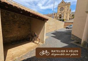 a bike parked next to a building with a clock tower at Le Studio Pop in Paray-le-Monial