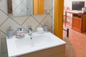 a bathroom with a white sink and a mirror at Agriturismo S'Ispiga in Cuglieri
