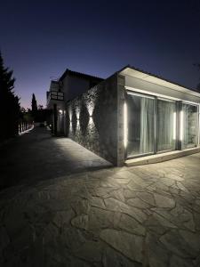 a building lit up at night at Olivujoj Villajoj - Deluxe Villa with Detached Pool House in Anavyssos +57 photos