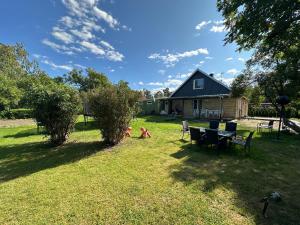 a backyard with a table and chairs and a house at Villa lugn och ro in Gustavsberg