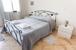 a bedroom with a large bed and a night stand at Agriturismo S'Ispiga in Cuglieri +30 photos