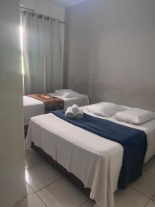two beds in a hotel room with towels on them at Hotel Real Centro in São Paulo