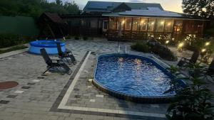 a swimming pool in a yard with a house at Ілона in Beregi