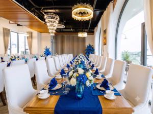 a long table with white chairs and a blue table at Sandals Everyday Hotel in Tuy Hoa