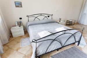 a bedroom with a large bed and two night stands at Agriturismo S'Ispiga in Cuglieri