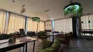 a restaurant with tables and chairs and windows at Air Solief in Tashkent