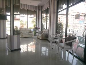 a living room with chairs and tables and windows at Grand Residence Jomtien in Jomtien Beach
