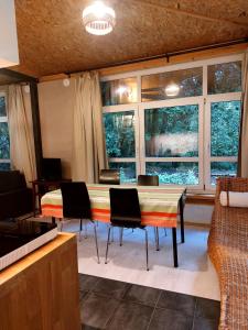 a living room with a table and chairs and windows at Apartament WERANDA in Paplin +12 photos