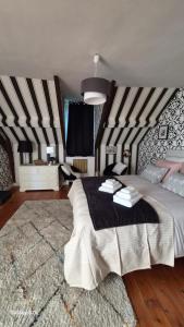 a bedroom with a large bed with black and white stripes at au fil de l'oust in Rohan