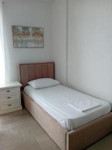 a bedroom with a bed and a nightstand next to a bed at Mimi's Apartments, Palasë in Palasë