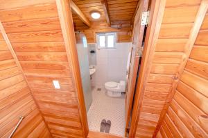 a small bathroom with a toilet in a wooden house at Dyne Resort in Jeju