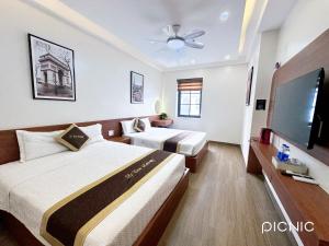 a hotel room with two beds and a flat screen tv at Lê Tâm E678 Hotel in Ha Long +19 photos
