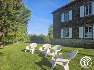 a row of white chairs in front of a building at Le grand gîte de souels in Almayrac