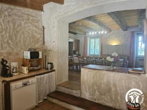 a kitchen with a counter and a dining room at Le grand gîte de souels in Almayrac