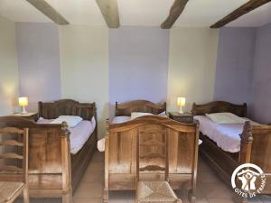 two twin beds in a room with two lamps at Le grand gîte de souels in Almayrac