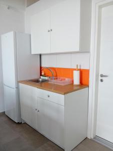 a kitchen with white cabinets and a sink at Mimi's Apartments, Palasë in Palasë